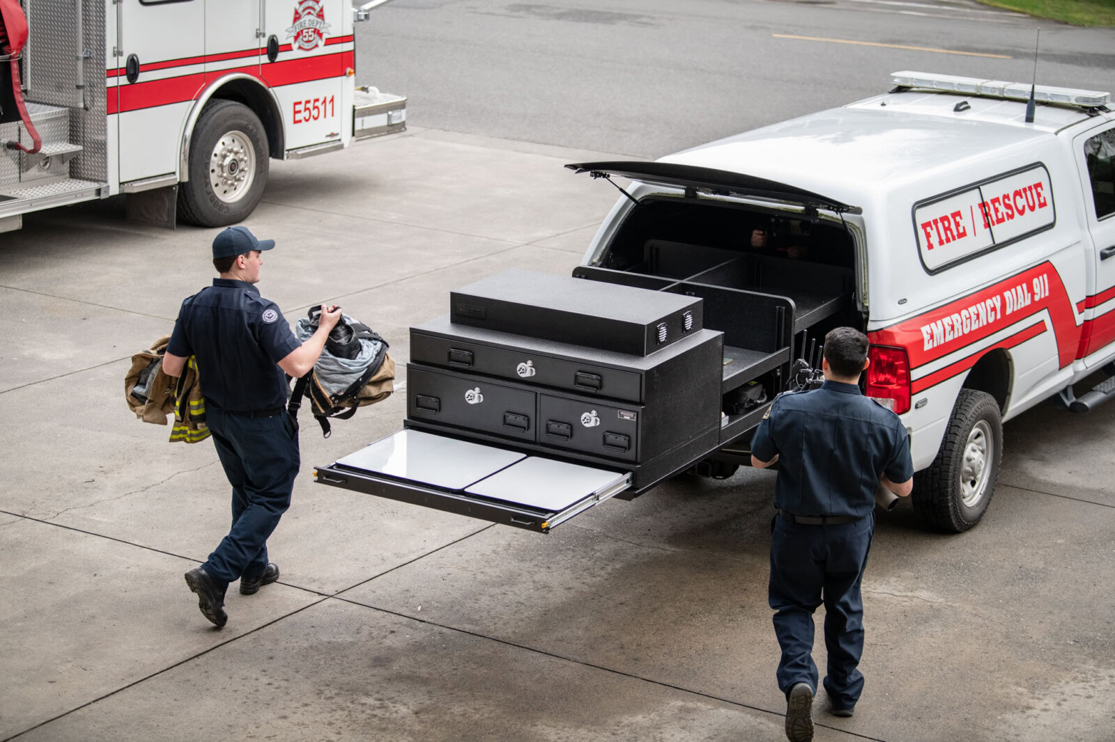 First responders load gear into the PL6 which is fully extended from their truck